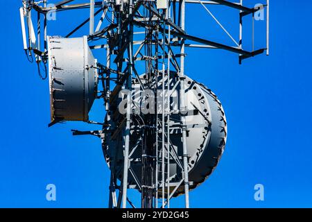 Eine Nahaufnahme und detaillierte Ansicht eines Mobilfunknetzes Basisstation mit Mikrowelle Antenne an Metall pylon behoben, Ursache für elektromagnetische Verschmutzung Stockfoto