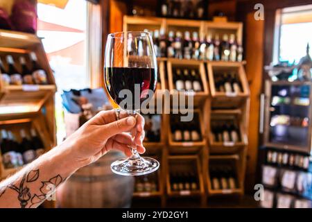 Tätowierte Hand mit einem Glas Rotwein Stockfoto