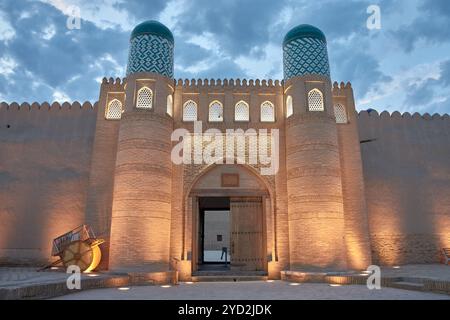 Das beleuchtete Haupttor des Khan-Palastes, Kunya Ark, während der Nacht in Chiwa, Usbekistan. Die sanfte Beleuchtung unterstreicht die Architektur Stockfoto