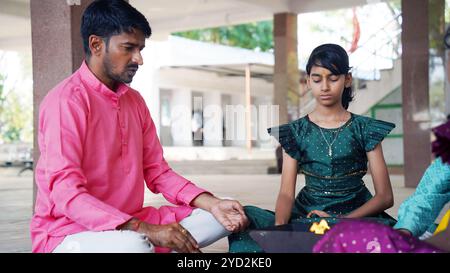 Eine traditionelle indische Familie, die sich in einem heiligen Yagya-Ritual engagiert, um die Energien im Haus zu harmonisieren. Die Feuerzeremonie wird für Vastu Shanti durchgeführt Stockfoto