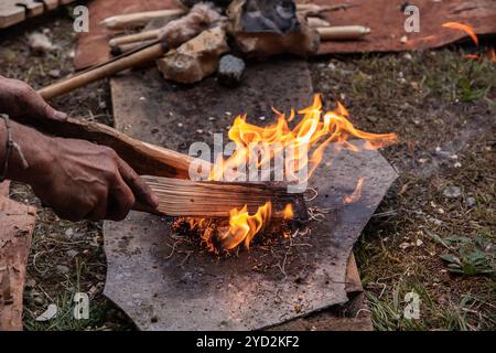 Hände, die Stifte im Stroh halten, als Feuerstarter Stockfoto