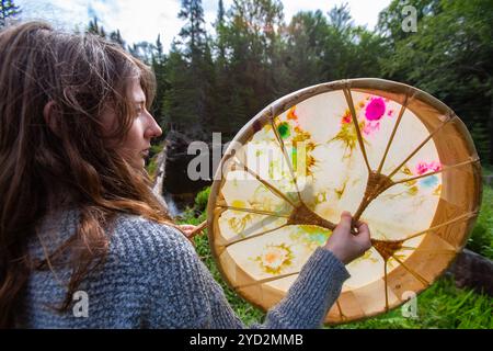 Frau, die heilige Trommel mit Pelzstock spielt Stockfoto