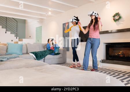 Weihnachten, gemeinsame Freundinnen, die Virtual-Reality-Spiele genießen, zu Hause Stockfoto