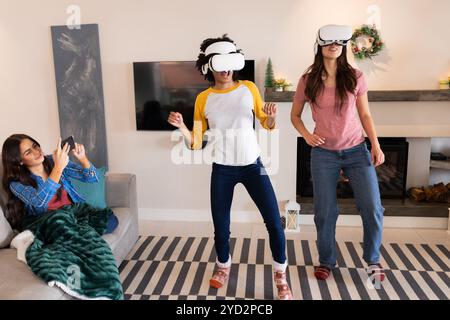 Gemeinsame Freundinnen, die während der Weihnachtsfeier Virtual-Reality-Spiele zu Hause genießen Stockfoto