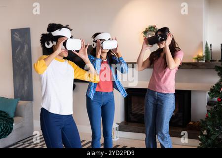 Gemeinsame Freundinnen genießen während der Weihnachtsfeier ein Virtual-Reality-Erlebnis zu Hause Stockfoto