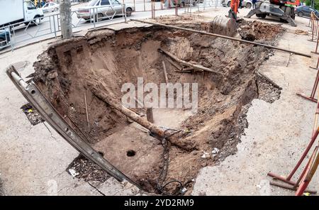 Bauarbeiten an rostigen Eisenrohren in einer Tiefe des ausgegrabenen Grabens. Austausch von Heizleitungen und Modernisierung der Heizung Stockfoto