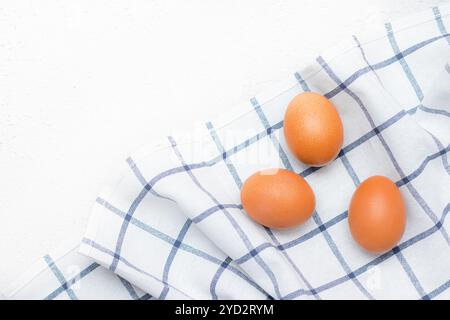 Hühnereier auf einem karierten Küchentuch auf einem Lichttisch. Das Konzept der landwirtschaftlichen Erzeugnisse und der natürlichen Ernährung. Artikel über Haushaltsprodukte Stockfoto