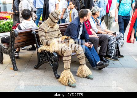 Moskau, Russland - 7. Juli 2019: Mann in einem schützenden Karnevalsanzug sitzt auf einer Bank Stockfoto