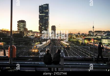 Entspannen Sie bei Sonnenuntergang auf der Modersohn-Brücke, Blick auf Eisenbahngleise, Züge und den 140 Meter hohen Amazonas-Büroturm Edge East Side, Berlin, 23,1 Stockfoto