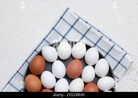 Hühnereier auf einem karierten Küchentuch auf einem Lichttisch. Das Konzept der landwirtschaftlichen Erzeugnisse und der natürlichen Ernährung. Artikel über Haushaltsprodukte Stockfoto