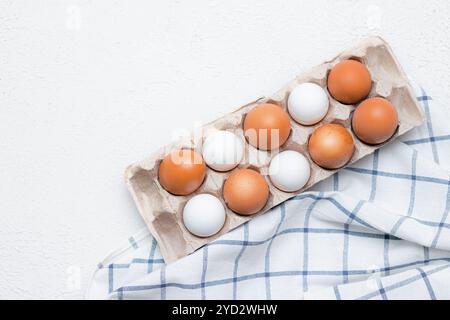 Hühnereier auf einem karierten Küchentuch auf einem Lichttisch. Das Konzept der landwirtschaftlichen Erzeugnisse und der natürlichen Ernährung. Artikel über Haushaltsprodukte Stockfoto