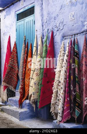 Chefchaouen, Marokko, 2. März 2024: Bunte Teppiche an der Wand in der historischen blauen Stadt Chefchaouen im Norden Marokkos, Afrika Stockfoto