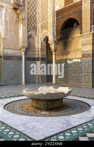 Fès, Marokko, 4. März 2024: Brunnen und Innenhof in der Parfümeurschule Al-Attarine Madrasa in der Innenstadt von Fès, Afrika Stockfoto