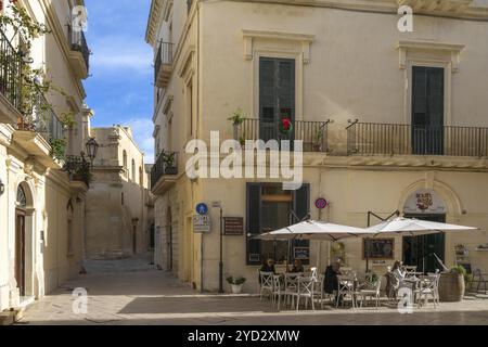 Lecce, Italien, 30. November 2023: Menschen, die in einem Straßencafé in der barocken Altstadt von Lecce in Apulien, Europa, einen Drink genießen Stockfoto