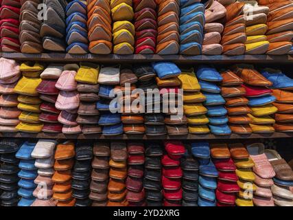 Fès, Marokko, 4. März 2024: Detailansicht der Regale voller farbenfroher Lederschuhe und Hausschuhe in der Medina von Fès in der Nähe der Tannerie Chouara, Afrika Stockfoto