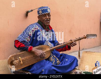 Marrakesch, Marokko, 23. März 2024: Straßenmusiker, der in der Innenstadt von Marrakesch ein westafrikanisches Xalam spielt Stockfoto