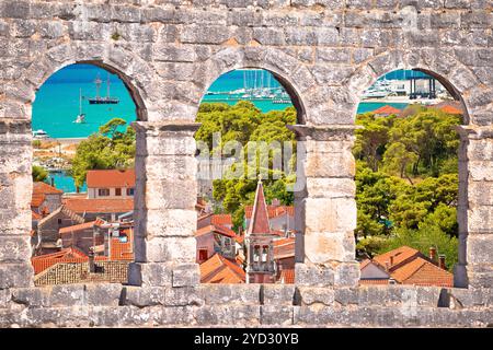 Die Dächer der Altstadt von Trogir und der türkisfarbene Blick auf den Archipel durch Steinfenster Stockfoto