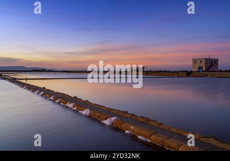 Blick auf die Landschaft der ruhigen Meersalzbecken und -Ebenen in der Nähe von Trapani und Paceco bei Sonnenuntergang Stockfoto