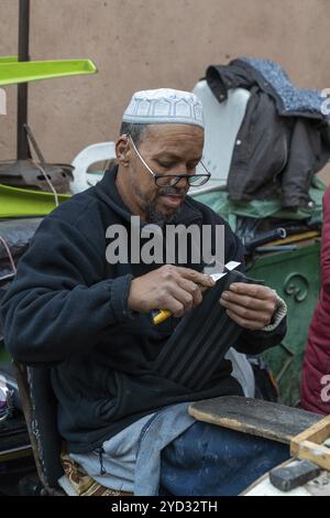 Marrakesch, Marokko, 23. März 2024: Traditionelle Schuhmacher im Souk der Marrakesch Medina reparieren alte Schuhe, Afrika Stockfoto