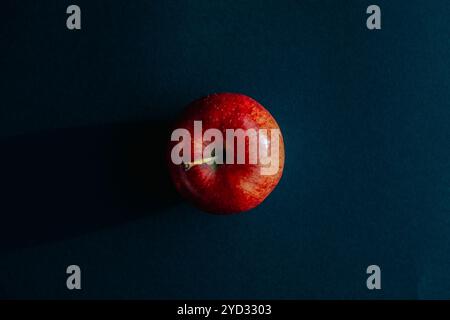Roter Apfel, der einen Schatten vor schwarzer Umrandung bildet Stockfoto