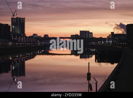 Die Skyline von Glasgow spiegelt sich während Eines wunderschönen Sonnenaufgangs im Fluss Clyde wider Stockfoto