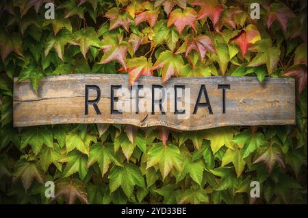 Rustikale Holz geschnitzte Zeichen für eine geistliche Einkehr gegen einen schönen grünen Hintergrund Stockfoto