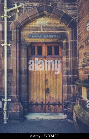 Eine alte hölzerne Tür an einer Hochschule einer renommierten Universität oder Schule Stockfoto