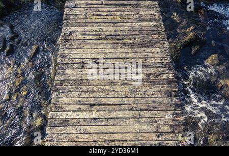 Konzeptionelle Bild von einem Wackeligen Holzsteg über einen Bach oder Creek oder Bach in Schottland Stockfoto