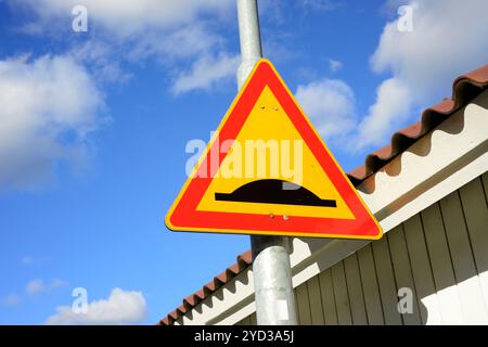 Straßenschild ungleichmäßige Straße zum Himmel Stockfoto