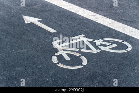 Fahrradsymbol auf einem Fahrradweg mit Richtungspfeil Stockfoto