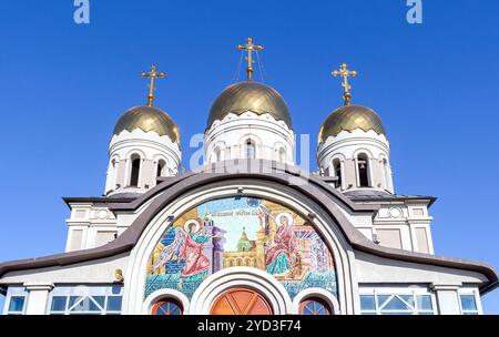 Mosaiksymbol an der Wand und goldene Kuppeln des Tempels Stockfoto