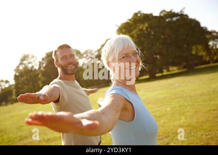Paare, dehnen und Portrait mit Yoga im Park für Bewegung, Balance und Mobilität in der Natur. Rücken, reife Menschen oder Krieger posieren auf Gras für Arm Stockfoto