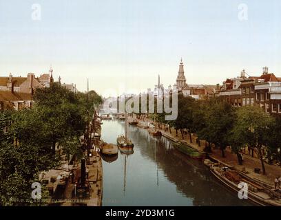 Kloveniersburgwal, einer der ältesten Kanäle, mit dem Turm der Zuiderkerk auf der rechten Seite, Amsterdam, Niederlande, CA 1895, historische digital restaurierte Reproduktion aus einem Original des 19. Jahrhunderts, Datum unbekannt, eine der ältesten Grachten, mit dem Turm der Zuiderkerk auf der rechten Seite, Niederlande, historisch, digital restaurierte Reproduktion von einer Vorlage aus dem 19. Jahrhundert. Jahrhundert, Datum nicht angegeben Stockfoto