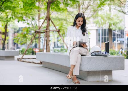 Intelligenter junger Ingenieur, der das Design von Tablet-Skizzen im Green Park nutzt. Umweltsparende Energieprojektgestalterin arbeitende Frauen. Stockfoto