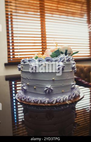 Ein hübscher lila Kuchen mit Blumenspitze, der einfach lecker und perfekt für jede Veranstaltung ist! Dieser Kuchen verleiht Ihren Feiern eine einzigartige Note. Stockfoto