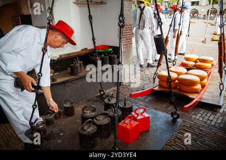 Wiegen von Käse in der Waage auf einem traditionellen niederländischen Käsemarkt in Alkmaar, Niederlande. September 2010 Stockfoto