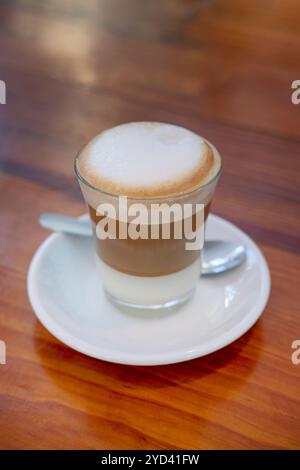 Leche y leche, ein traditionelles spanisches Getränk auf Kaffeebasis, ein heißes Getränk, das aus Schichten cremiger Kondensmilch, Espresso Shot und Milchschaum besteht Stockfoto