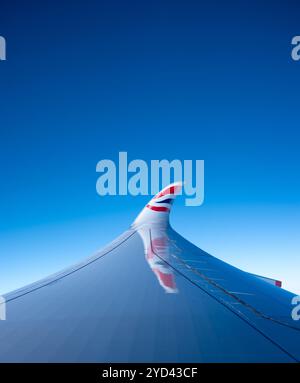 Der Flügel eines Flugzeugs der British Airways vor einem strahlend blauen Himmel. Stockfoto
