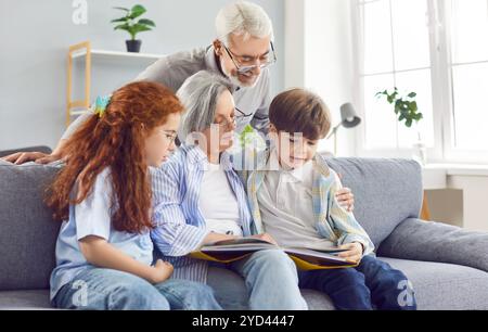 Großmutter liest ihren Enkeln zu Hause ein Buch, Nahaufnahme Stockfoto