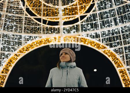 Eine Frau genießt die Weihnachtsbeleuchtung in ihrer Stadt. Stockfoto