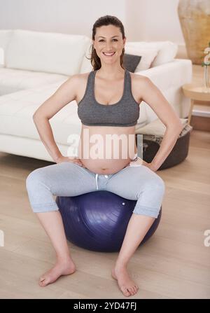 Porträt, schwangere Frau und Turnball für Training, Stretching und Fitness zu Hause für Trainingsplan. Weibliche Person, glücklich und bereit für Bewegung Stockfoto