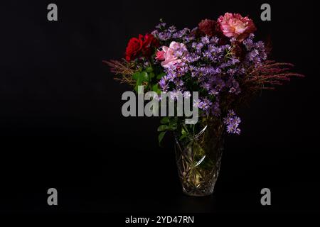 Strauß von Herbstblumen in einer Vintage Glasvase auf einem schwarzen bac Stockfoto