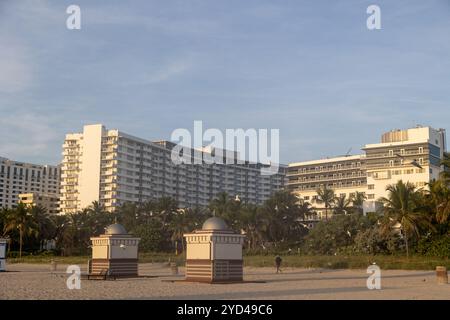 Hotels in Miami Beach und Palmen mit Strandhütten im Vordergrund Stockfoto