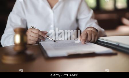 Arbeitsrechtliches Konzept. Der Anwalt unterschreibt ein juristisches Dokument mit den Richtern. Stockfoto