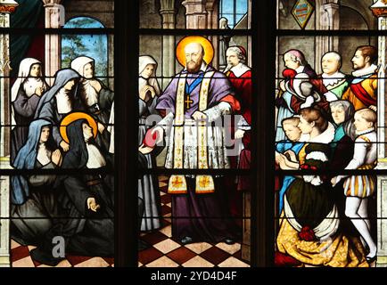 St. Franziskus de Sales überreicht St. Jeanne de Chantal in den Verfassungen des Ordens der Besuche, Buntglas, St. S. Stockfoto