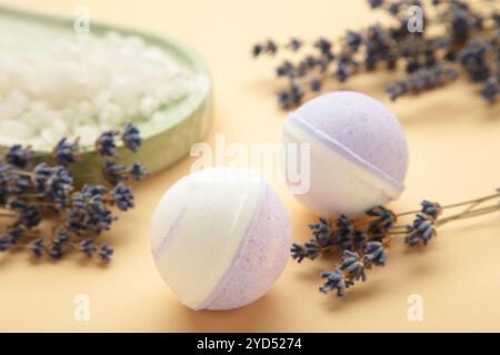 Naturkosmetik. Handgemachte Lavendelbadebomben und Lavendelblüten auf beigem Hintergrund. Draufsicht Stockfoto