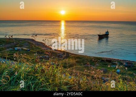 Wunderschöner Sonnenuntergang über dem Meer mit Öltankschiff im Vordergrund. Nevelsk, Sachalin, Russland Stockfoto