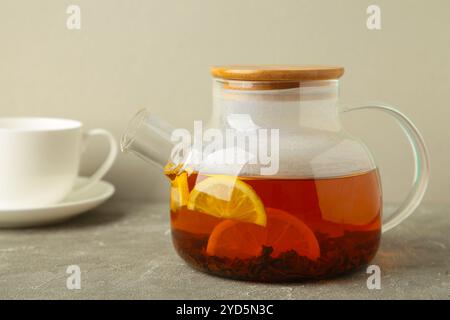 Teekanne aus Glas mit Tee und Tasse auf grauem Hintergrund. Draufsicht Stockfoto