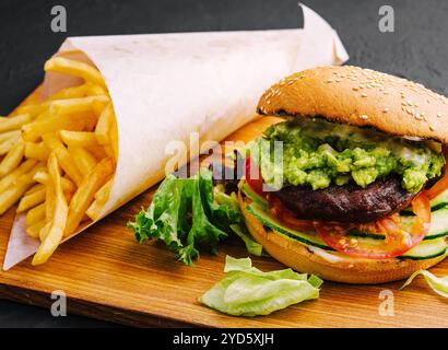 Burger mit Pommes frites auf Holztablett Stockfoto