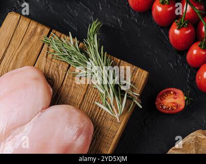 Rohe Hähnchenfilets auf hölzernem Schneidebrett, Draufsicht Stockfoto